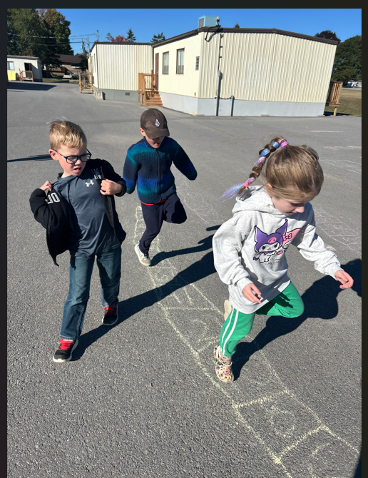 Three students playing outside in the schoolyard