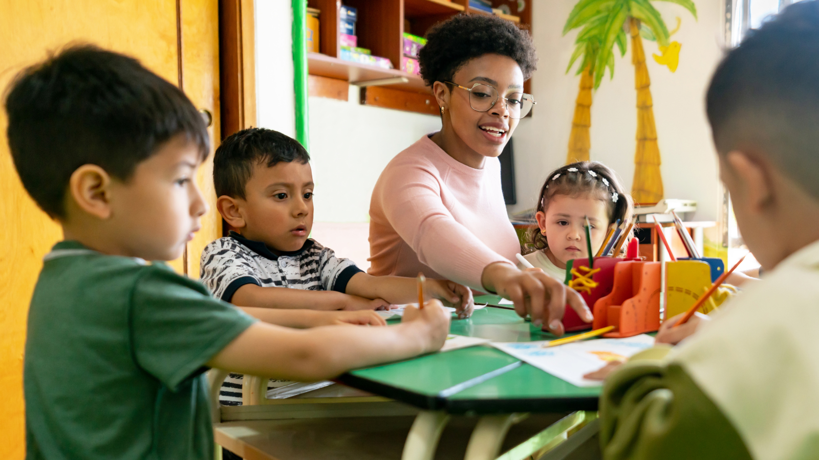 Teacher working with students at a table